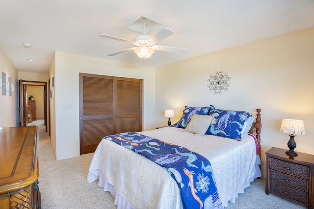 bedroom featuring ceiling fan, a closet, and light carpet