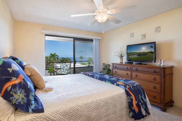 carpeted bedroom featuring access to outside, ceiling fan, and a textured ceiling