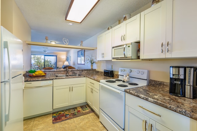 kitchen featuring white appliances, dark stone counters, sink, a textured ceiling, and white cabinetry