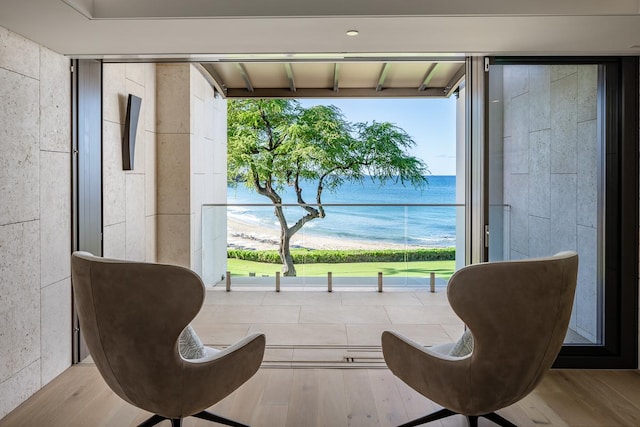 sitting room featuring a water view and light hardwood / wood-style flooring