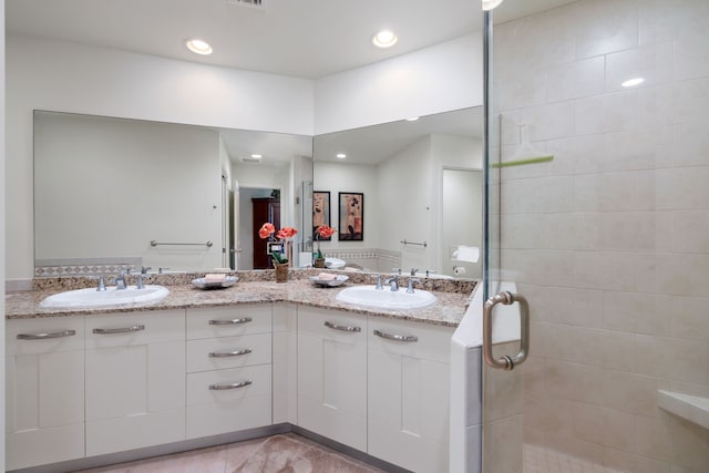 bathroom featuring tile patterned flooring, vanity, and walk in shower