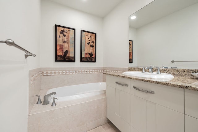 bathroom featuring tile patterned floors, vanity, and tiled bath