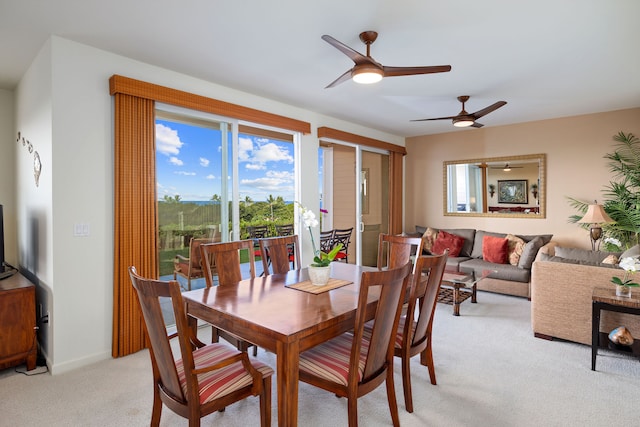 dining area featuring ceiling fan and light carpet