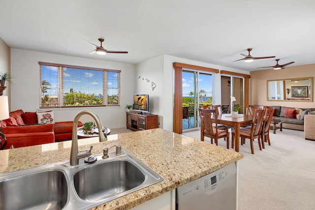 kitchen with white dishwasher, light stone countertops, sink, and light carpet