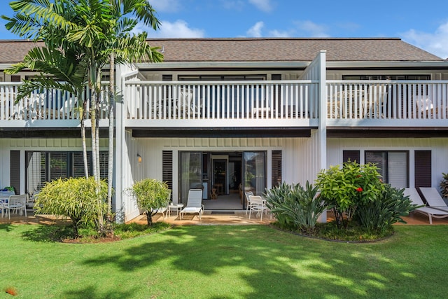 back of property featuring a yard and a balcony