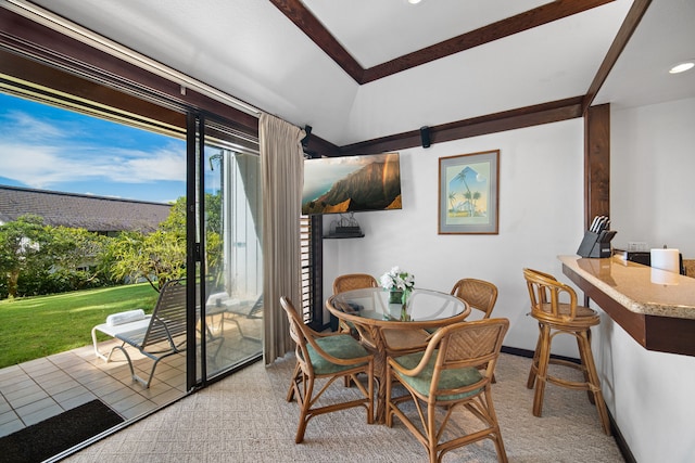 carpeted dining room featuring a barn door and lofted ceiling