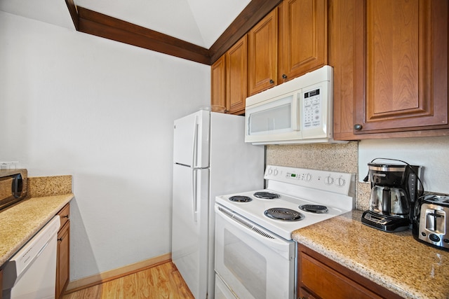 kitchen with decorative backsplash, light stone counters, light hardwood / wood-style flooring, and white appliances