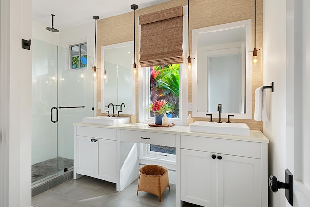 bathroom with tile patterned flooring, vanity, and walk in shower