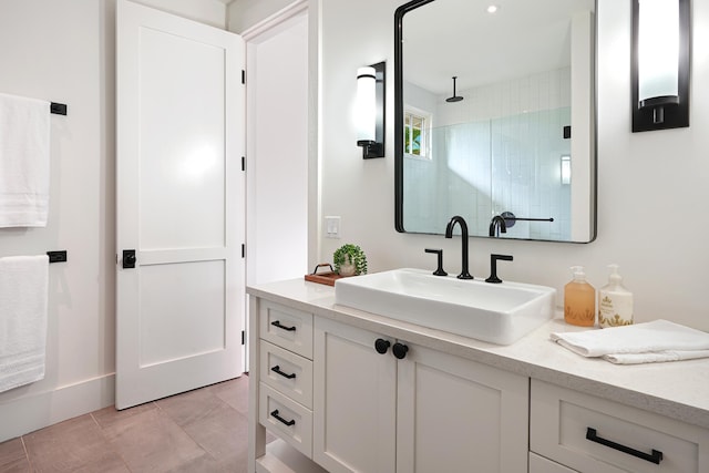 bathroom featuring a tile shower, tile patterned floors, and vanity