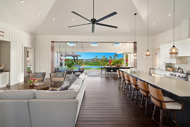 living room with high vaulted ceiling, ceiling fan, a healthy amount of sunlight, and sink