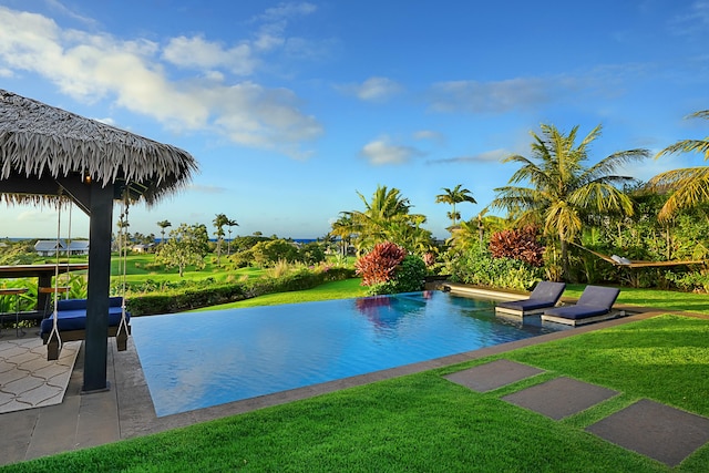 view of pool featuring a yard and a patio