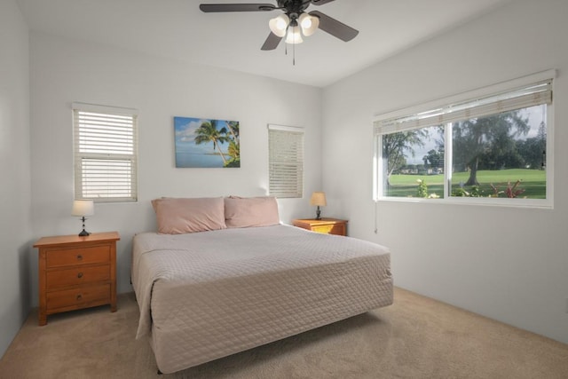 carpeted bedroom featuring ceiling fan and multiple windows