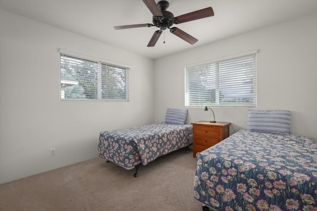 bedroom with ceiling fan, light carpet, and multiple windows