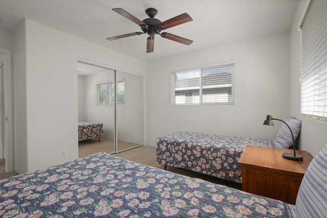 bedroom with ceiling fan, a closet, and light colored carpet