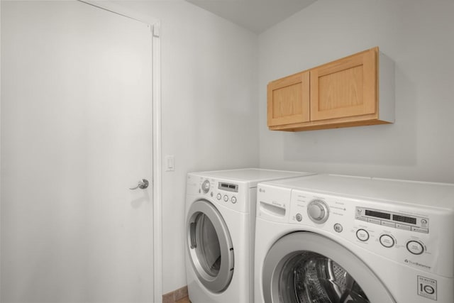 laundry room with washer and dryer and cabinets
