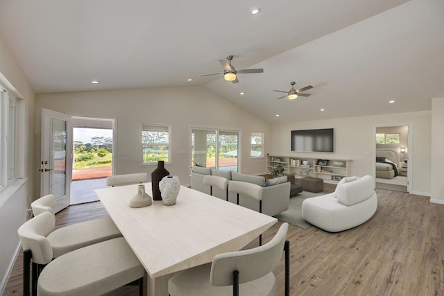 dining space with ceiling fan, light hardwood / wood-style floors, and lofted ceiling