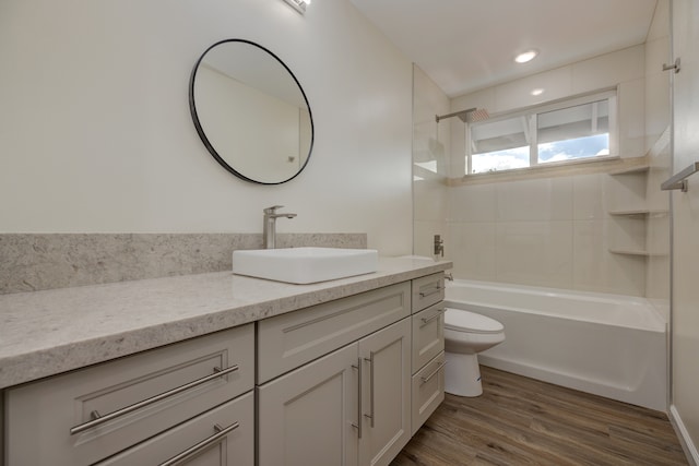 full bathroom with hardwood / wood-style floors, vanity, bathing tub / shower combination, and toilet