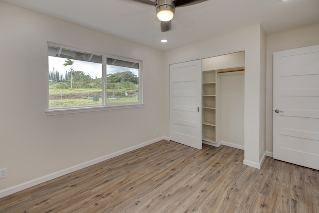 unfurnished bedroom with ceiling fan, light wood-type flooring, and a closet