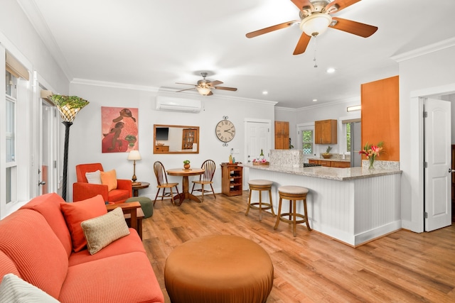 living room with ceiling fan, light wood-type flooring, ornamental molding, and an AC wall unit