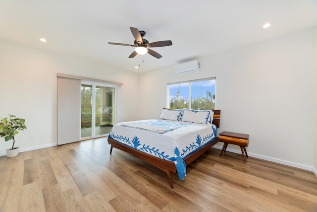 bedroom featuring a wall mounted air conditioner, access to outside, light hardwood / wood-style flooring, and ceiling fan