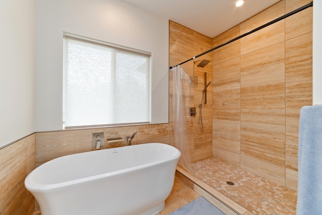 bathroom featuring separate shower and tub, tile patterned flooring, and tile walls