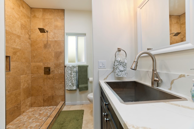 bathroom with tile patterned flooring, a tile shower, toilet, and sink