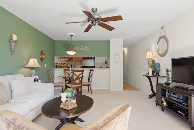 carpeted living room with ceiling fan