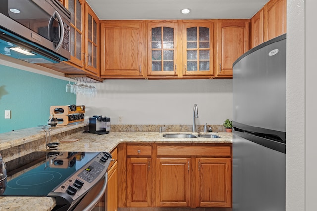 kitchen featuring light stone countertops, sink, and appliances with stainless steel finishes