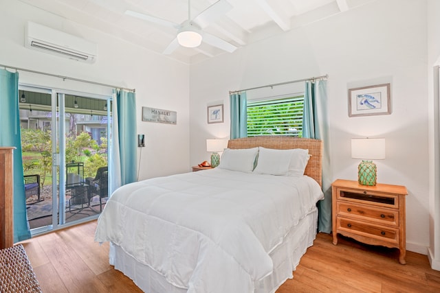 bedroom featuring ceiling fan, beam ceiling, light hardwood / wood-style flooring, an AC wall unit, and access to outside