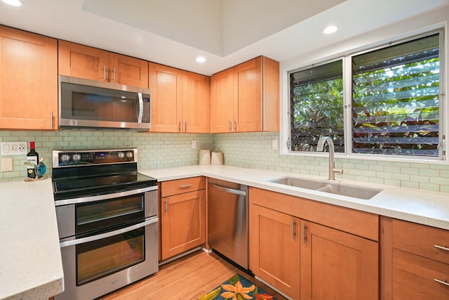 kitchen featuring light hardwood / wood-style floors, stainless steel appliances, sink, and backsplash