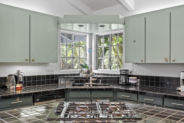 kitchen with tile counters, stainless steel gas stovetop, and sink