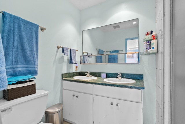 bathroom with a shower with door, vanity, and toilet