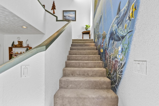 stairway with a textured ceiling