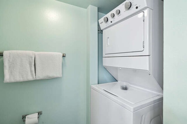 washroom featuring stacked washing maching and dryer