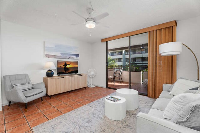 tiled living room with ceiling fan