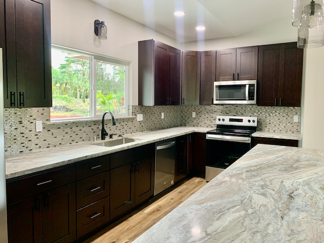 kitchen with light hardwood / wood-style flooring, sink, stainless steel appliances, and tasteful backsplash