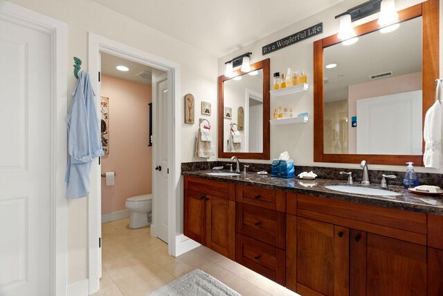 bathroom with tile patterned flooring, vanity, and toilet