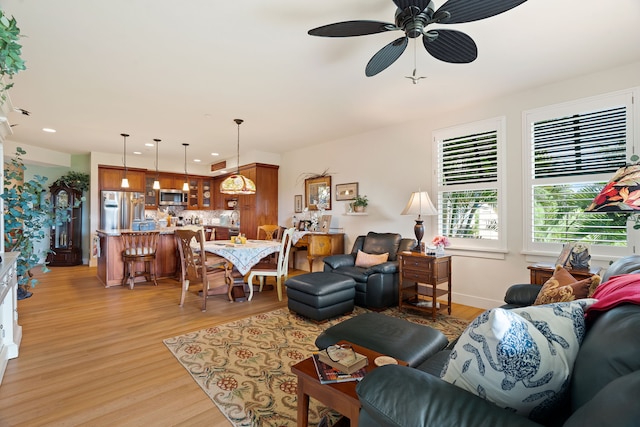 living room with ceiling fan and light hardwood / wood-style flooring