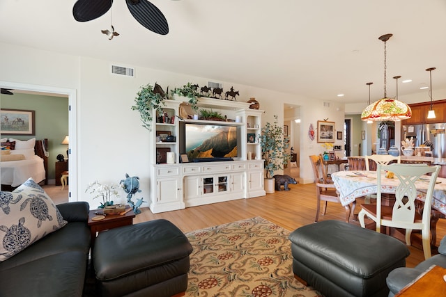 living room featuring ceiling fan and light hardwood / wood-style floors