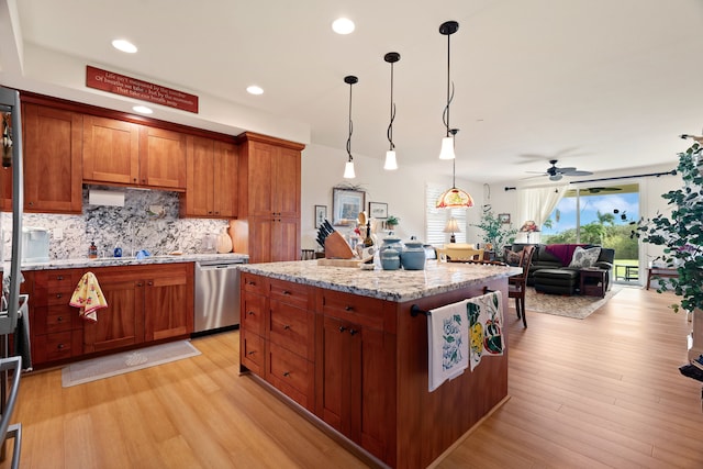 kitchen featuring light stone countertops, dishwasher, a center island, pendant lighting, and light hardwood / wood-style floors