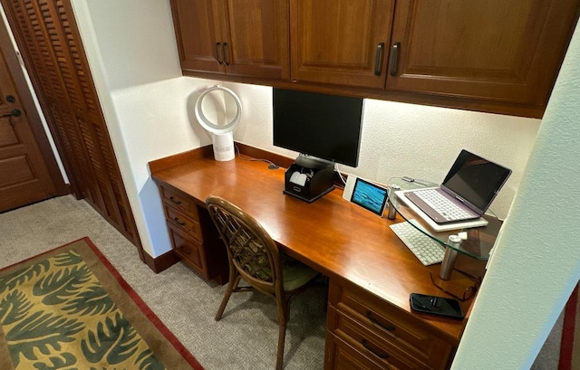 home office featuring light carpet and built in desk