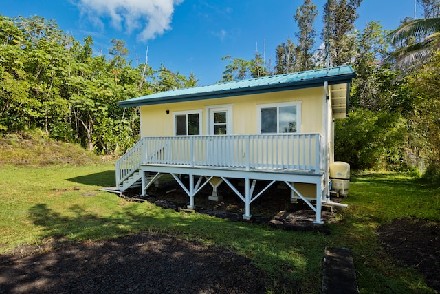 rear view of house featuring a lawn and a deck