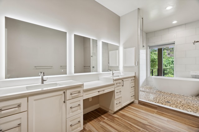 bathroom with hardwood / wood-style floors, vanity, and walk in shower