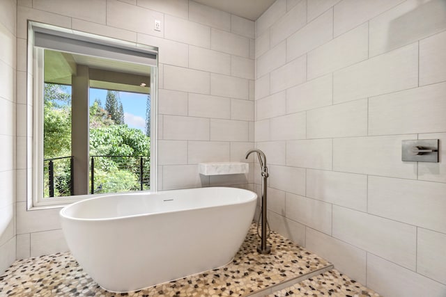 bathroom featuring tile walls and a bathing tub