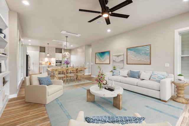 living room featuring light wood-type flooring and ceiling fan