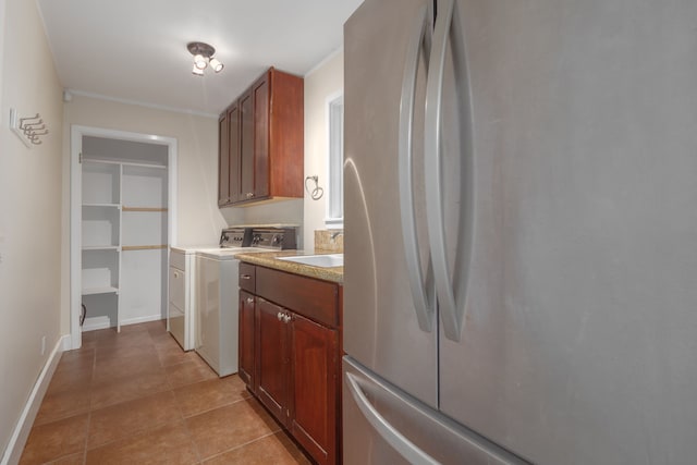 kitchen featuring stainless steel fridge, light tile patterned floors, and sink