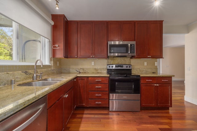 kitchen featuring decorative backsplash, wood-type flooring, stainless steel appliances, and sink