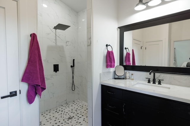 bathroom featuring a tile shower and vanity