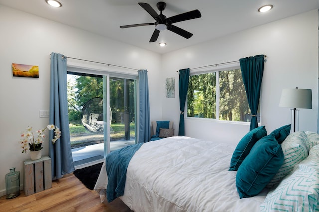 bedroom featuring access to outside, multiple windows, ceiling fan, and hardwood / wood-style flooring