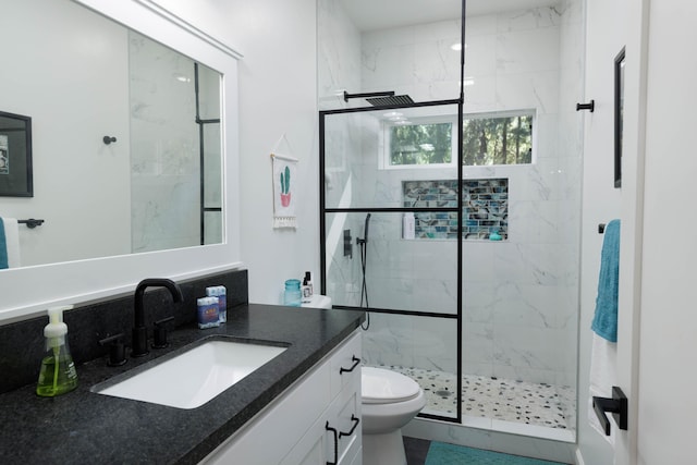 bathroom with vanity, toilet, and a shower with door